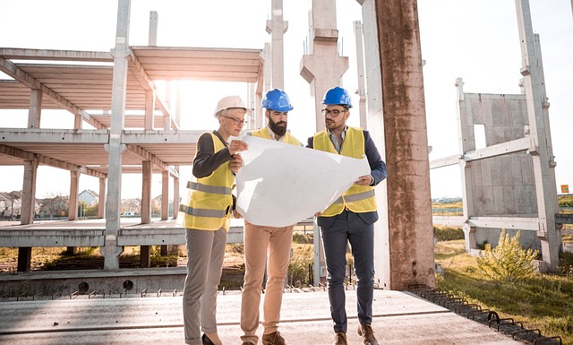 Engineers reviewing blueprints on construction site